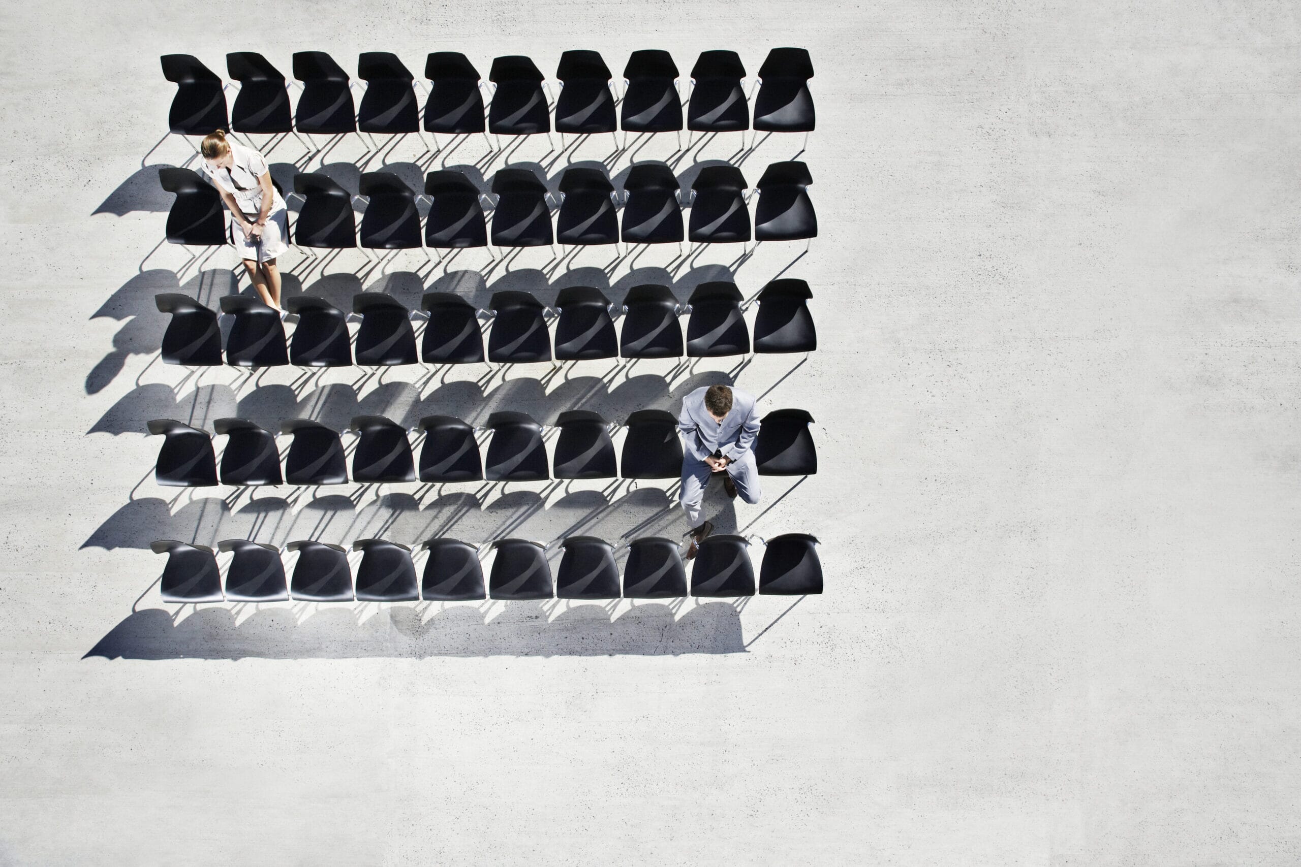 Businesspeople sitting in office chairs on sidewalk